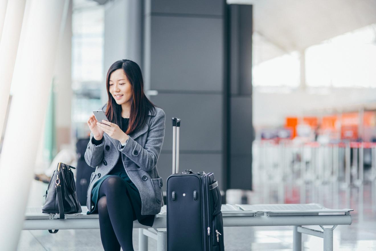 Woman-using-mobile-phone-in-airport-smart-codes-program.jpg