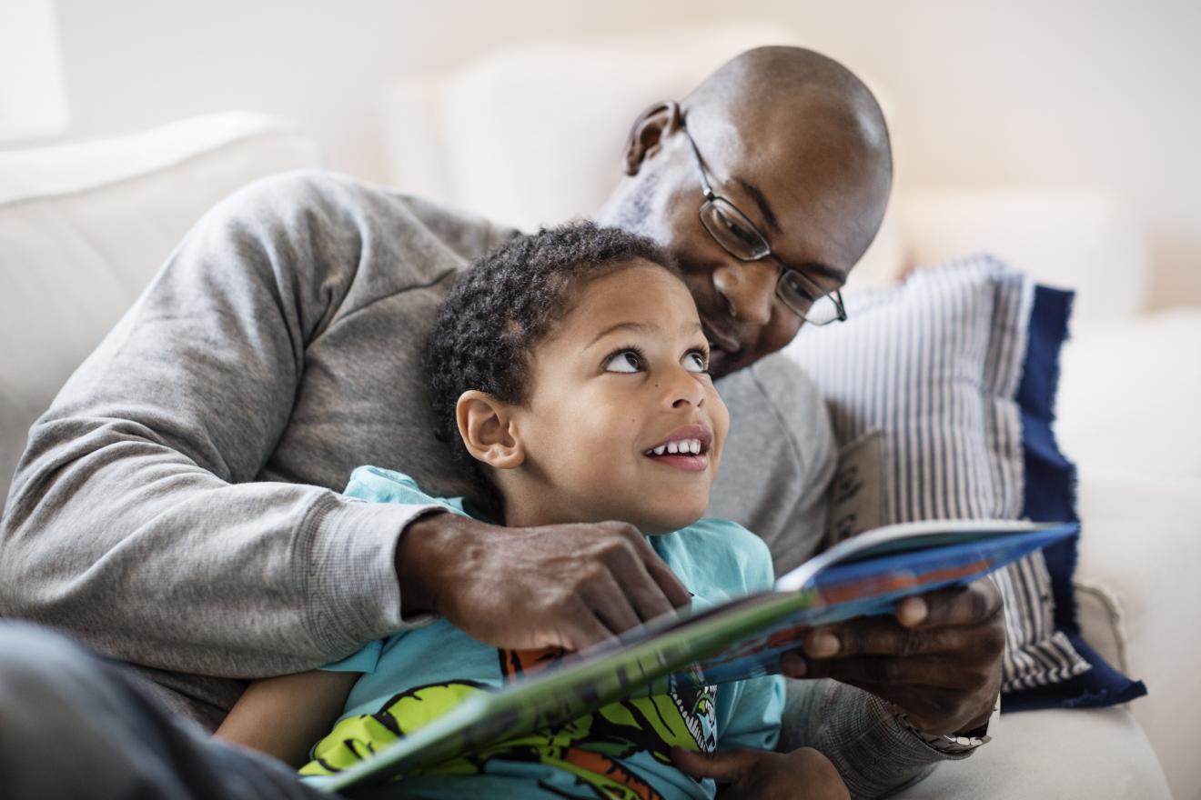 A father and son enjoying a book they received from a program they joined via short code enrollment