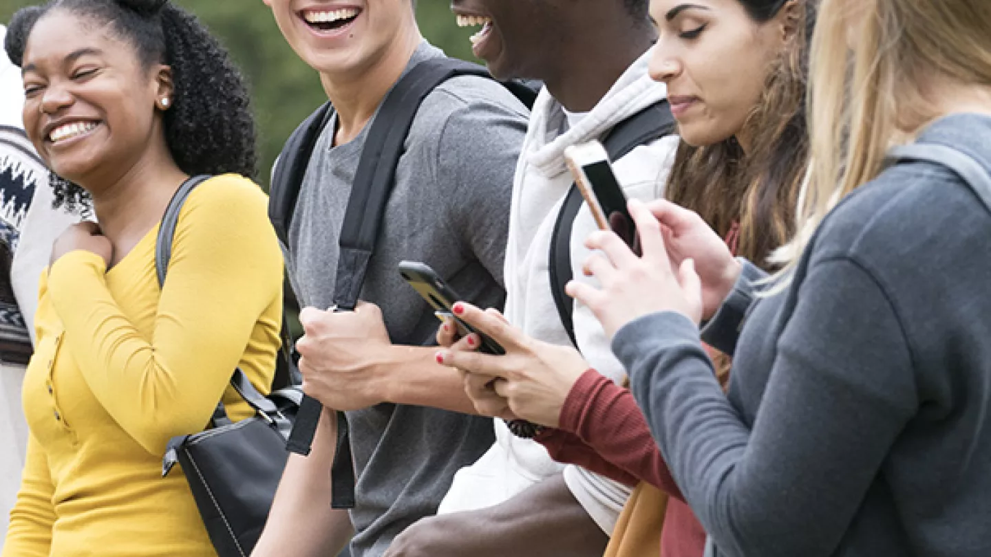 College students walking and using mobile phones short codes program