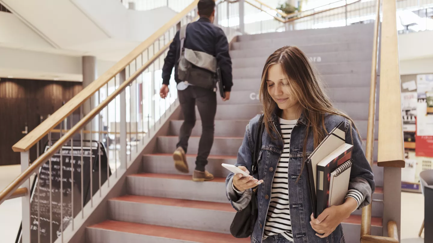Student uses her smartphone to check on her scholarship status
