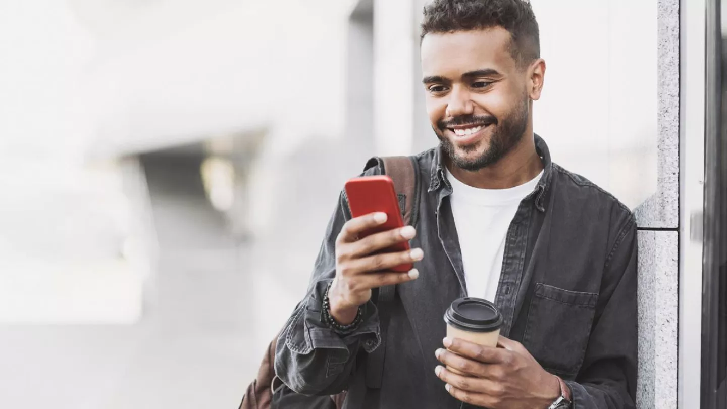 Man smiling while looking at a smartphone