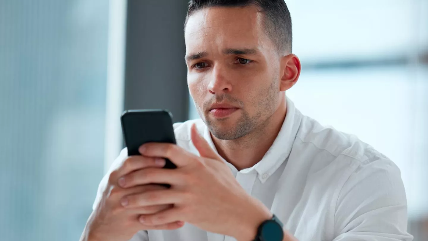 Man looking at a phone with a concerned look on his face