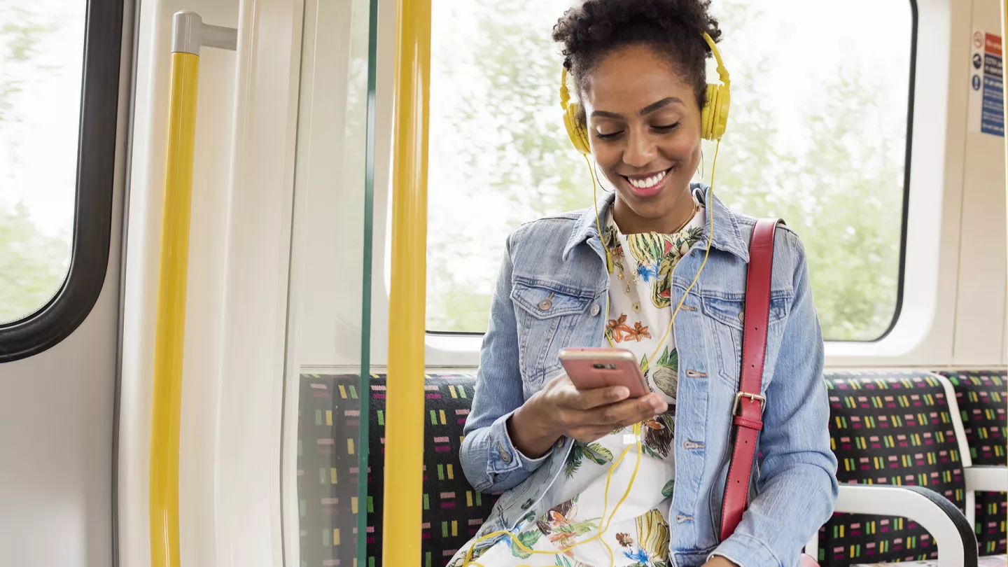 Image of a woman on a bus looking at her phone