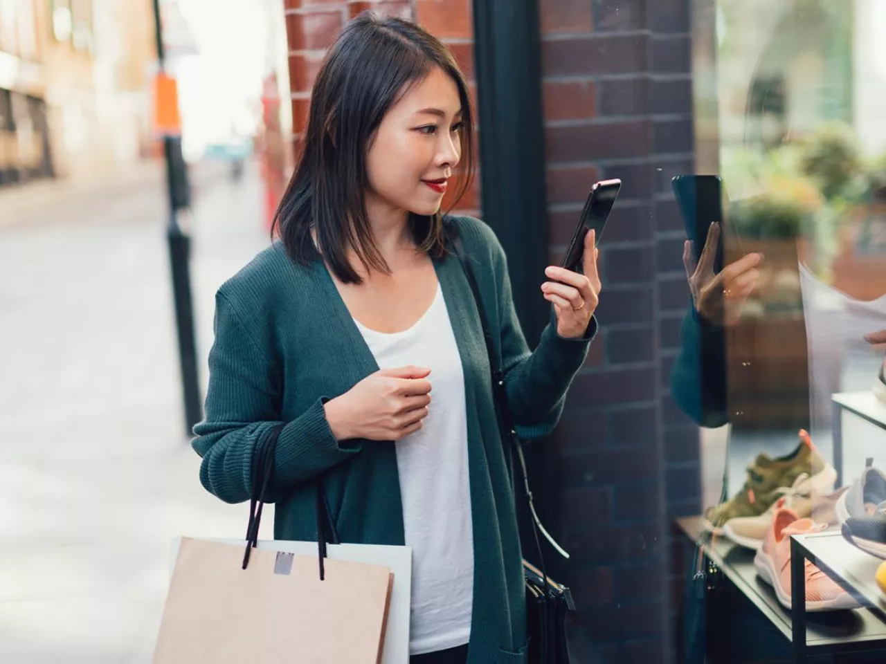 A distracted woman checks her phone while shopping