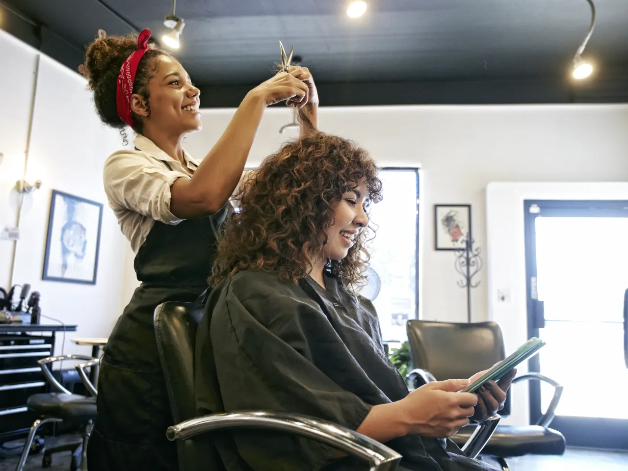 A woman getting her hair done at an appointment she made using the salon's short code scheduler