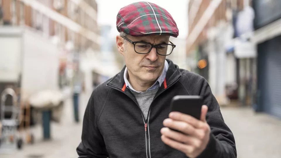 Man looking concerned after receiving fraud alert on smartphone